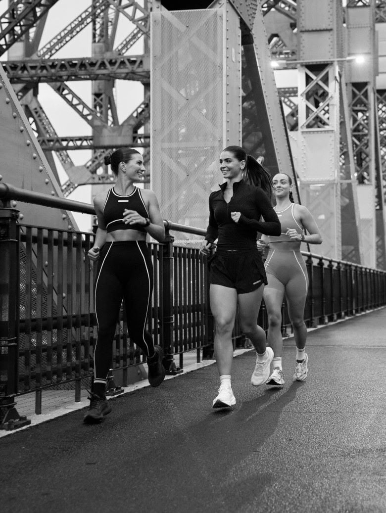 Three women running on bridge